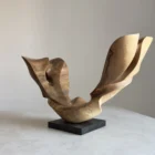 open-arc-walnut-wood-sculpture-main-ewebohome Hand carved walnut wood sculpture Open Arc displayed on a black granite base in natural light