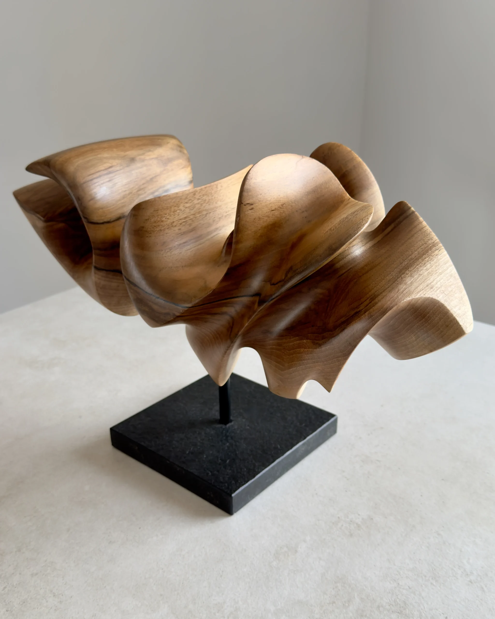 abstract walnut wood sculpture on black granite base, hand carved modern wood art