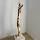 full view tall abstract wood sculpture walnut on pedestal minimalist space unfolding form