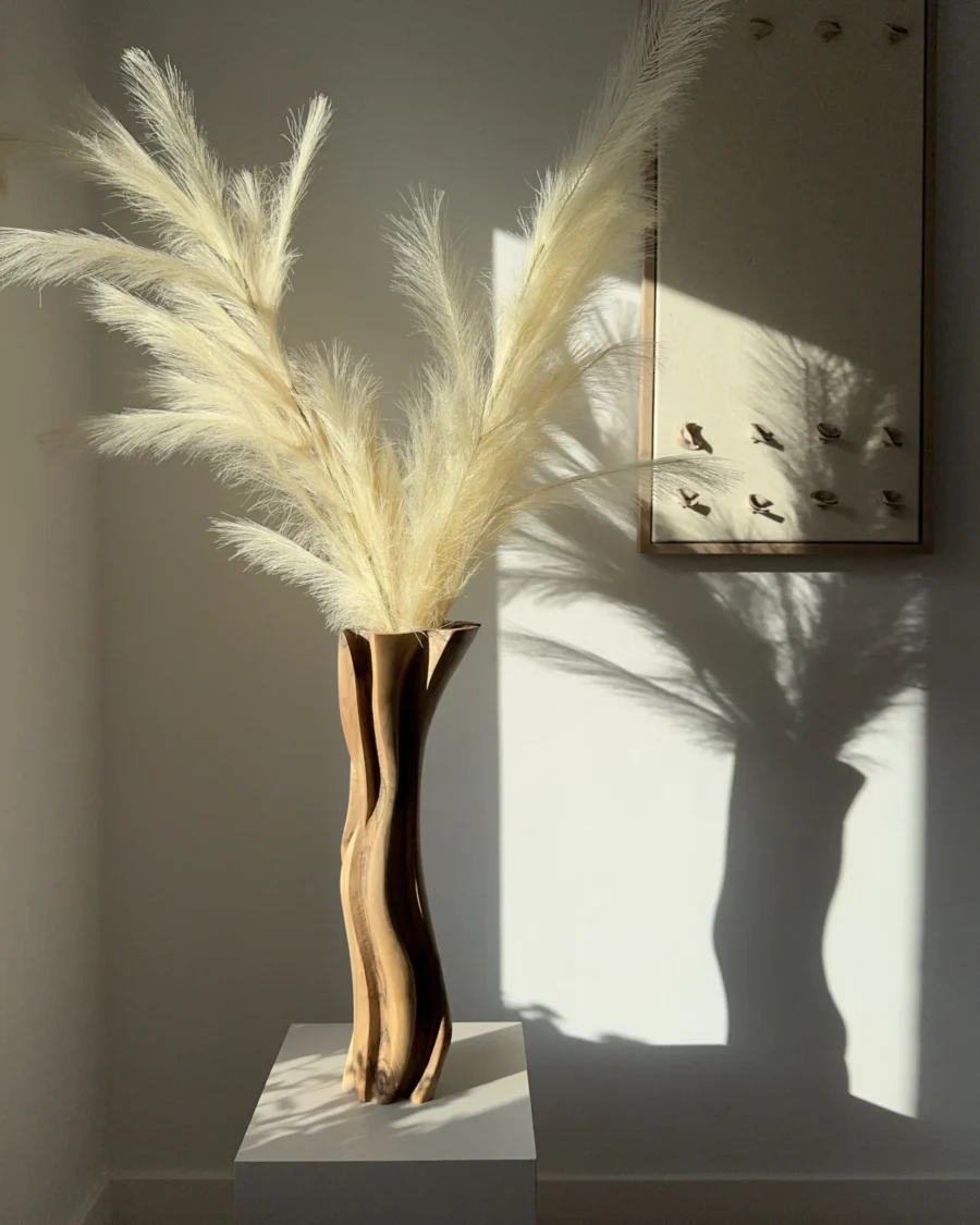 Abstract walnut wood vase with pampas grass, warm tones and soft organic silhouette in interior