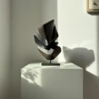 abstract wood sculpture shadow split hand carved applewood sculpture on granite base in natural light