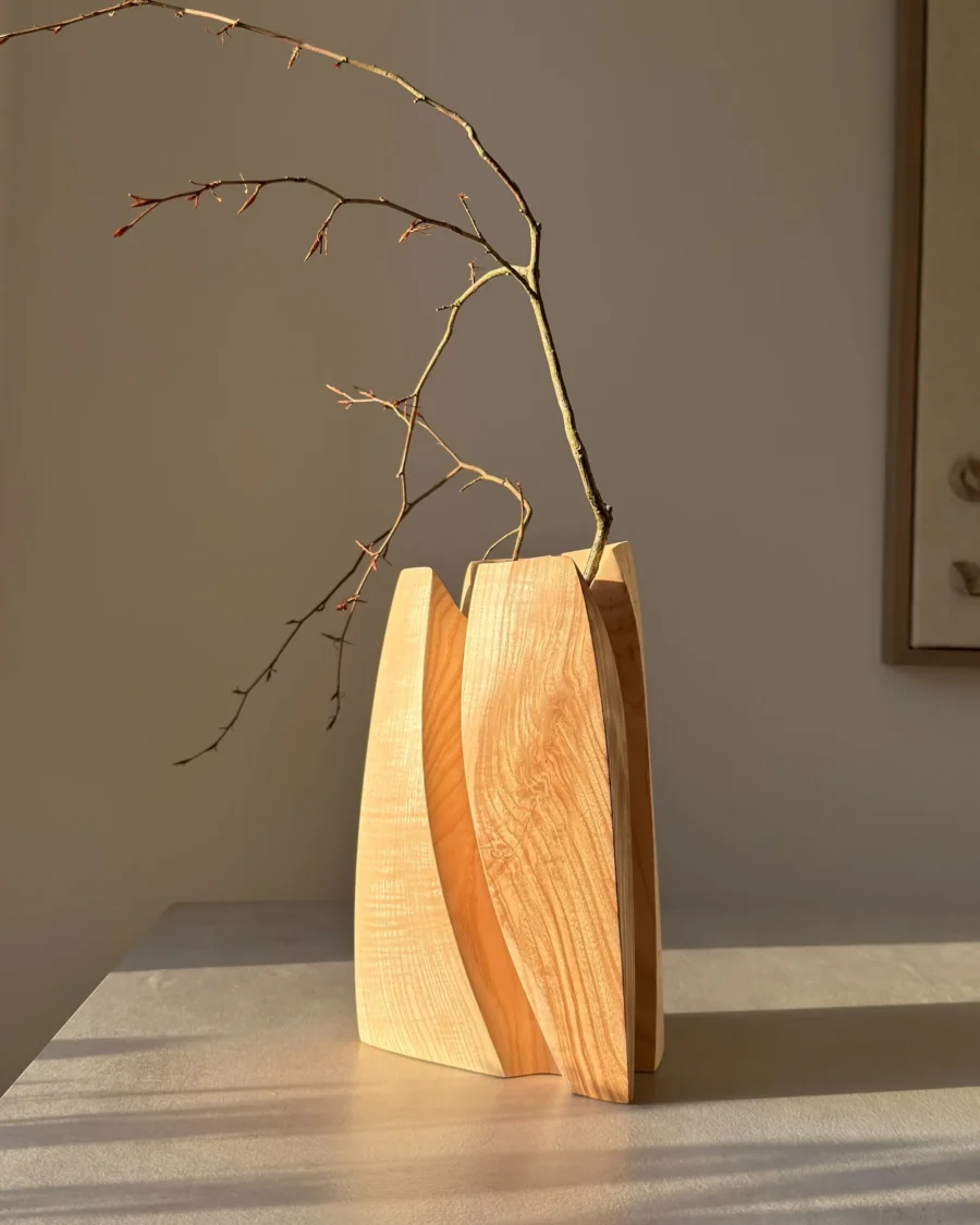 Hand carved ash wood vase with branch, abstract sculptural form, natural light
