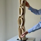 Large hand carved walnut sculpture Ivory Flow shown with hands for scale and detail