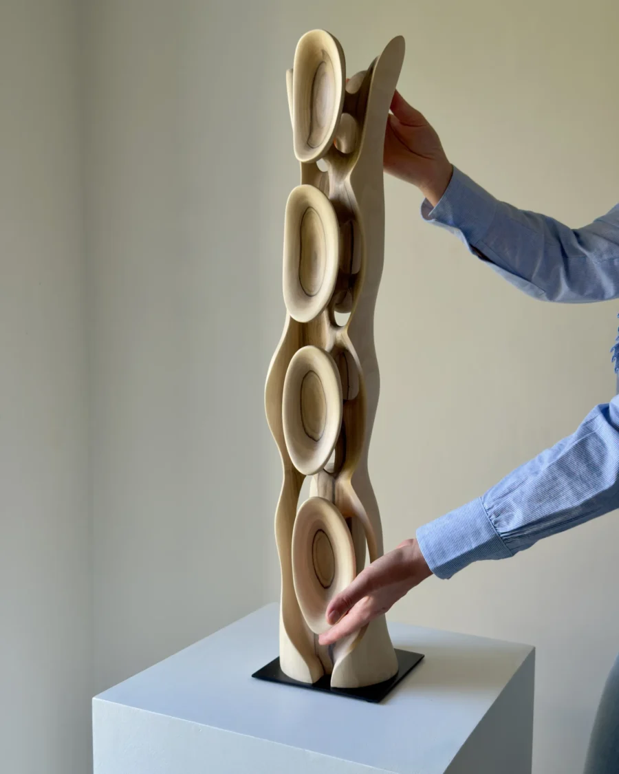 Large hand carved walnut sculpture Ivory Flow shown with hands for scale and detail