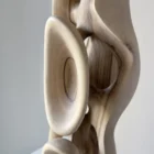 Close-up of carved walnut sculpture showing natural grain transitions and hollow organic structure