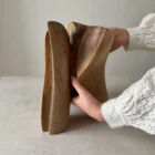 close view of hand interacting with abstract wood sculpture, showing size and organic shape