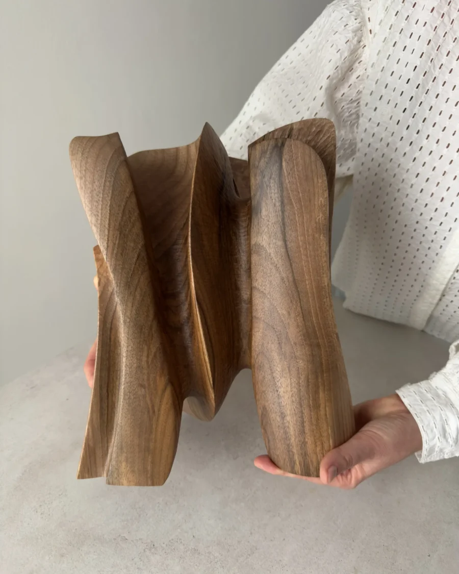 hand holding abstract wooden sculpture for scale, hand carved walnut art piece size reference