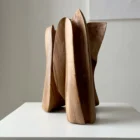 abstract wooden sculpture in minimalist interior setting, hand carved walnut art object for modern space
