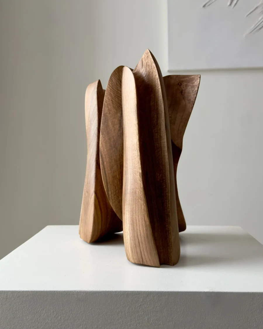 abstract wooden sculpture in minimalist interior setting, hand carved walnut art object for modern space