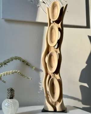 Tall abstract walnut wood sculpture Ivory Flow displayed in soft natural light with sculptural shadows on wall