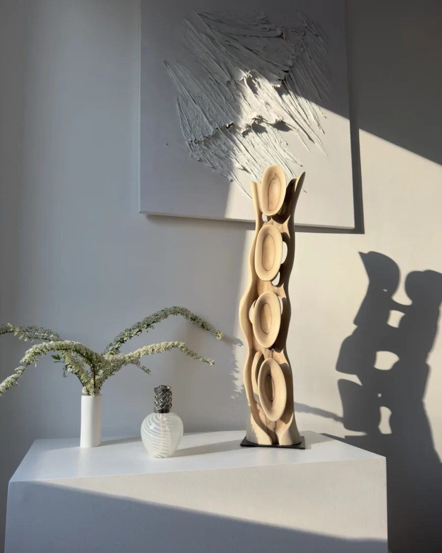 Hand carved walnut sculpture Ivory Flow with organic openings casting dynamic shadows in interior