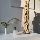 Side view of abstract walnut sculpture Ivory Flow showing flowing vertical form and carved openings