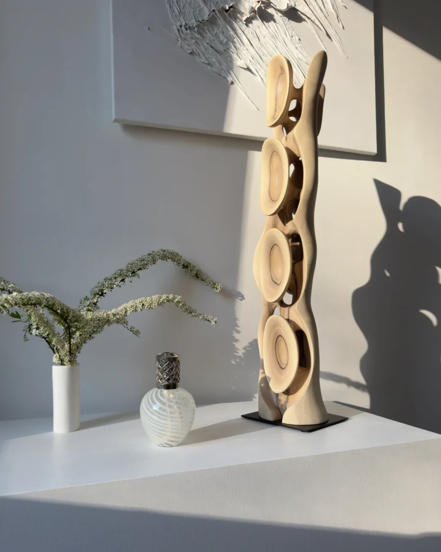 Side view of abstract walnut sculpture Ivory Flow showing flowing vertical form and carved openings