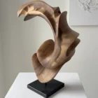 Side view of abstract wooden sculpture with open arc form and layered curves in aged walnut