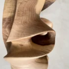 Detail of textured recessed area in hand-carved walnut sculpture with visible carving marks