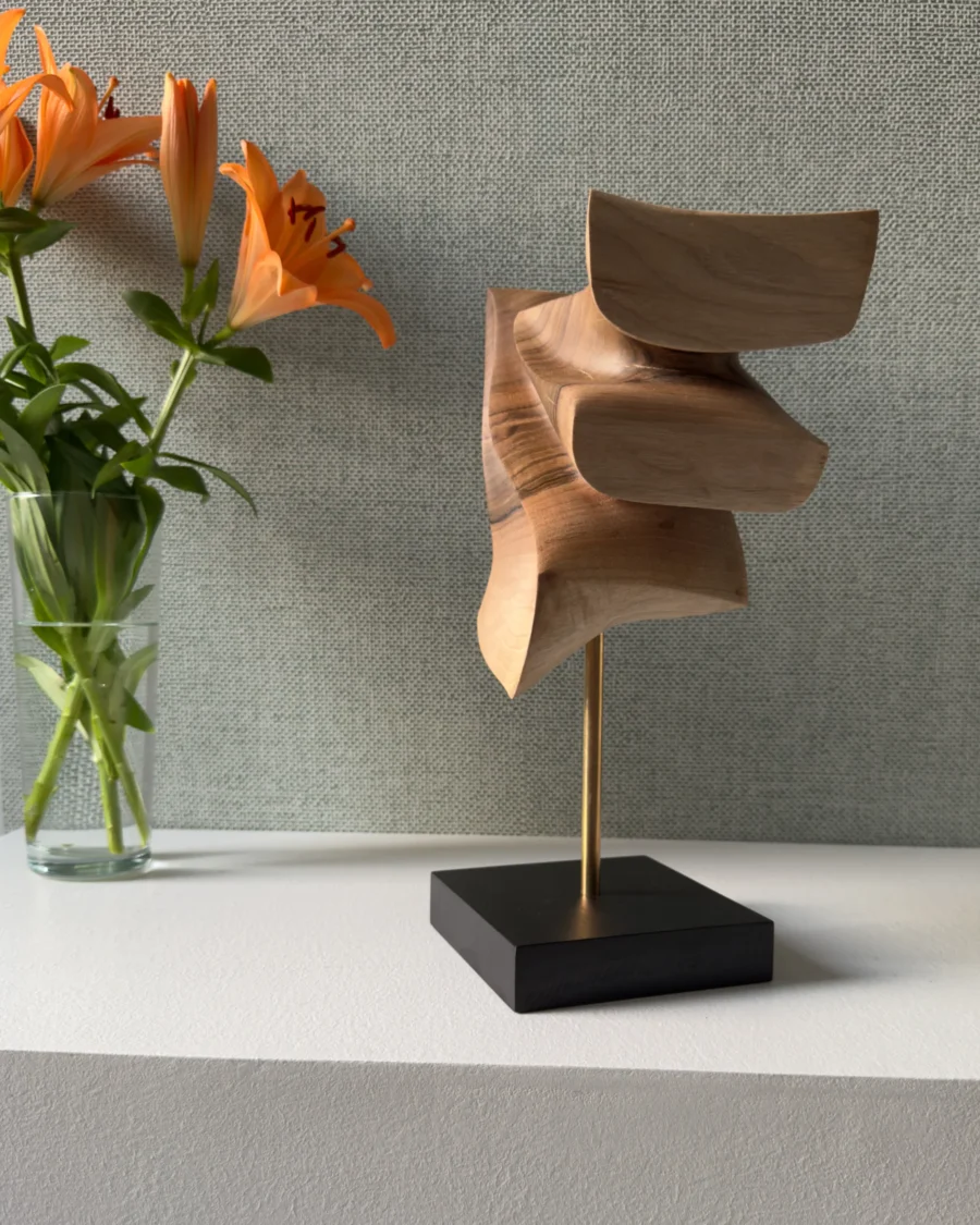 Abstract wood sculpture Velora placed in artistic interior with soft botanical background