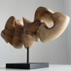 Abstract walnut wood sculpture side view revealing flowing organic form and horizontal composition