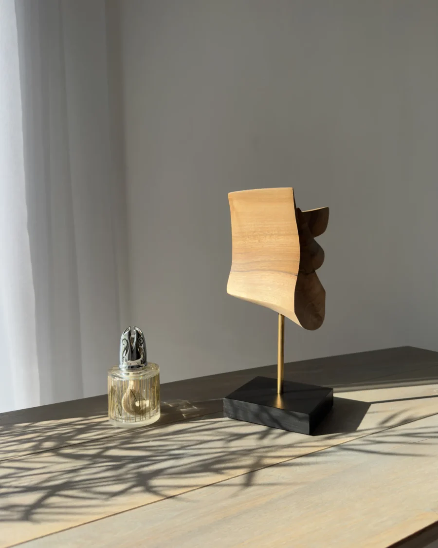 Side view of abstract walnut sculpture Velora highlighting curved organic silhouette