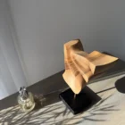 Modern walnut sculpture Velora styled with decorative objects in contemporary interior setting