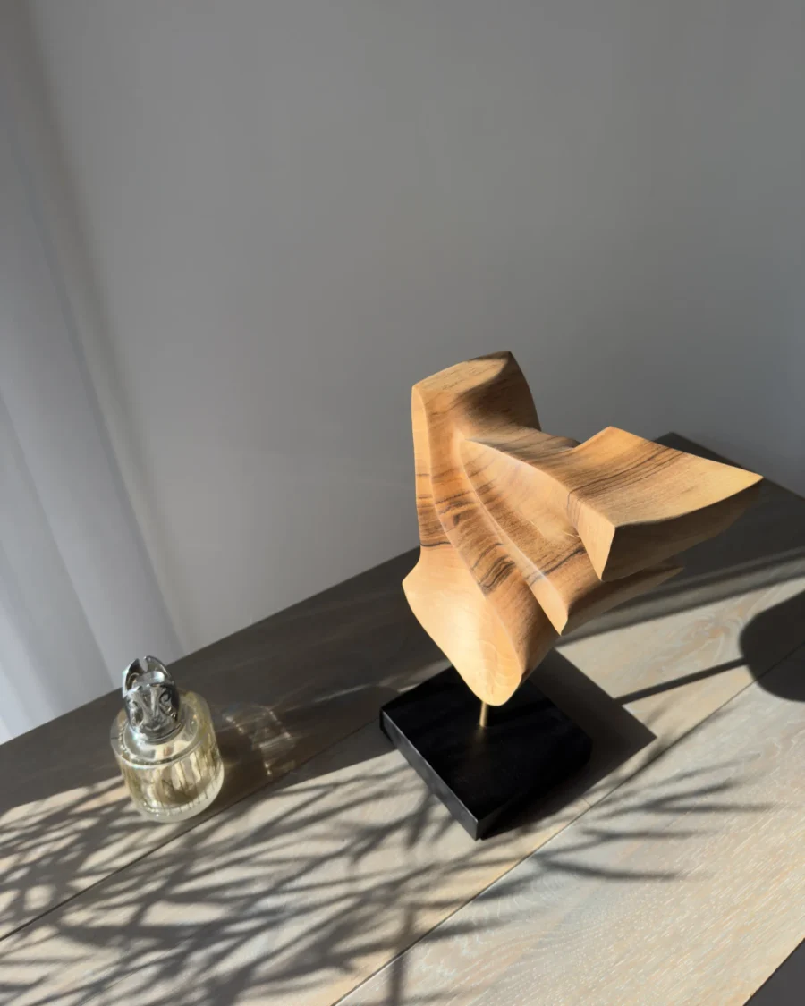 Modern walnut sculpture Velora styled with decorative objects in contemporary interior setting