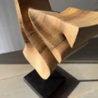Close-up of hand carved walnut wood sculpture showing natural grain and smooth surface detail