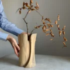 Wooden sculptural vase with dried branch, handmade walnut piece shown in human scale