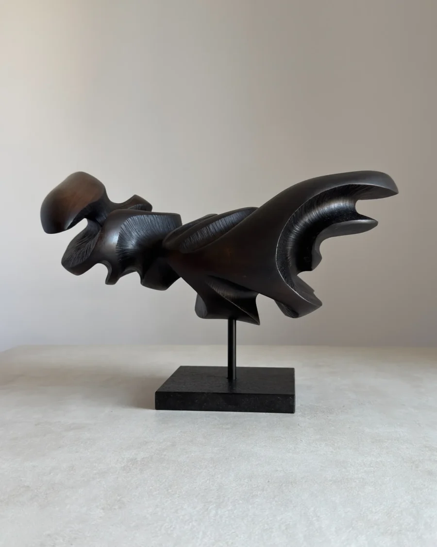 asymmetrical wooden sculpture black wax side view flowing form