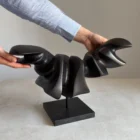 hand holding abstract wood sculpture showing scale and texture