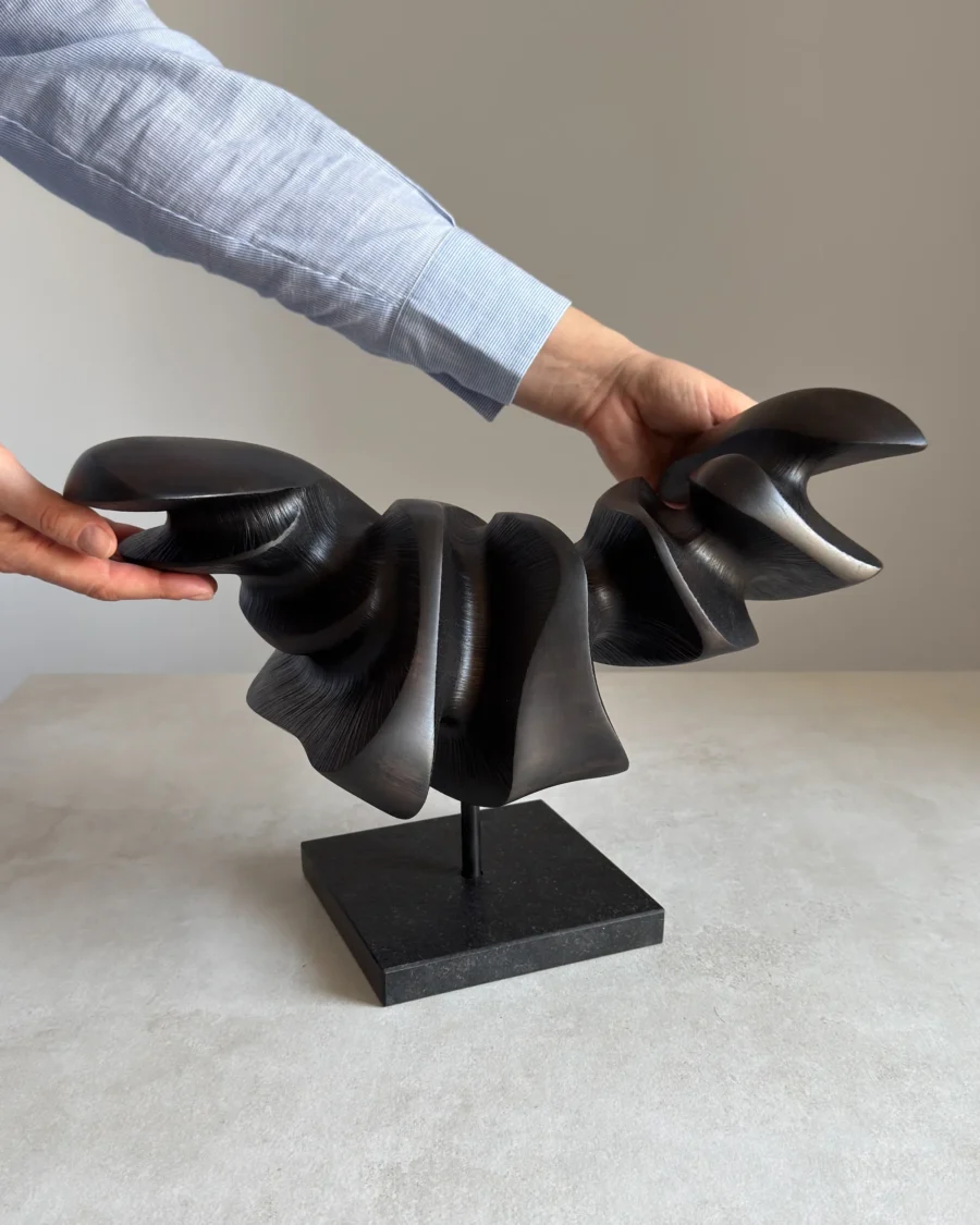 hand holding abstract wood sculpture showing scale and texture