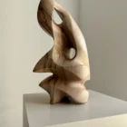 Side view of hand carved walnut sculpture with smooth flowing lines and natural wood grain