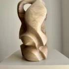 Abstract wood sculpture in walnut showing curved form and inner opening – contemporary handmade artwork