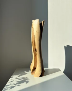 abstract wood vase hand carved from walnut with a subtle leaning form in natural sunlight