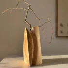 Hand carved wooden vase casting shadow, minimalist interior object