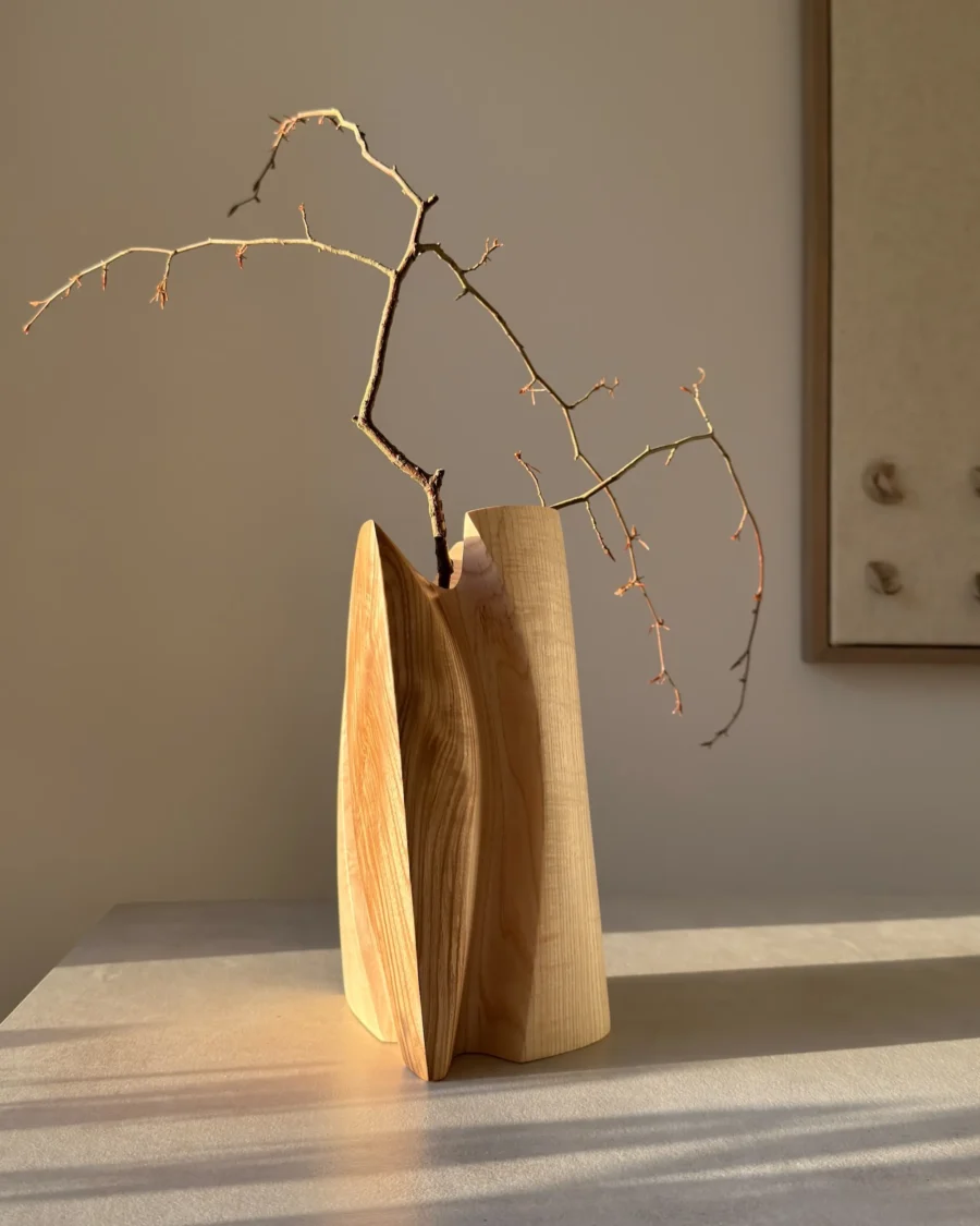Hand carved wooden vase casting shadow, minimalist interior object