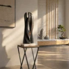 abstract wood sculpture Close Distance in modern interior charred maple sculpture on stone base with natural light