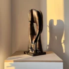 hand carved wood sculpture with strong shadow on wall