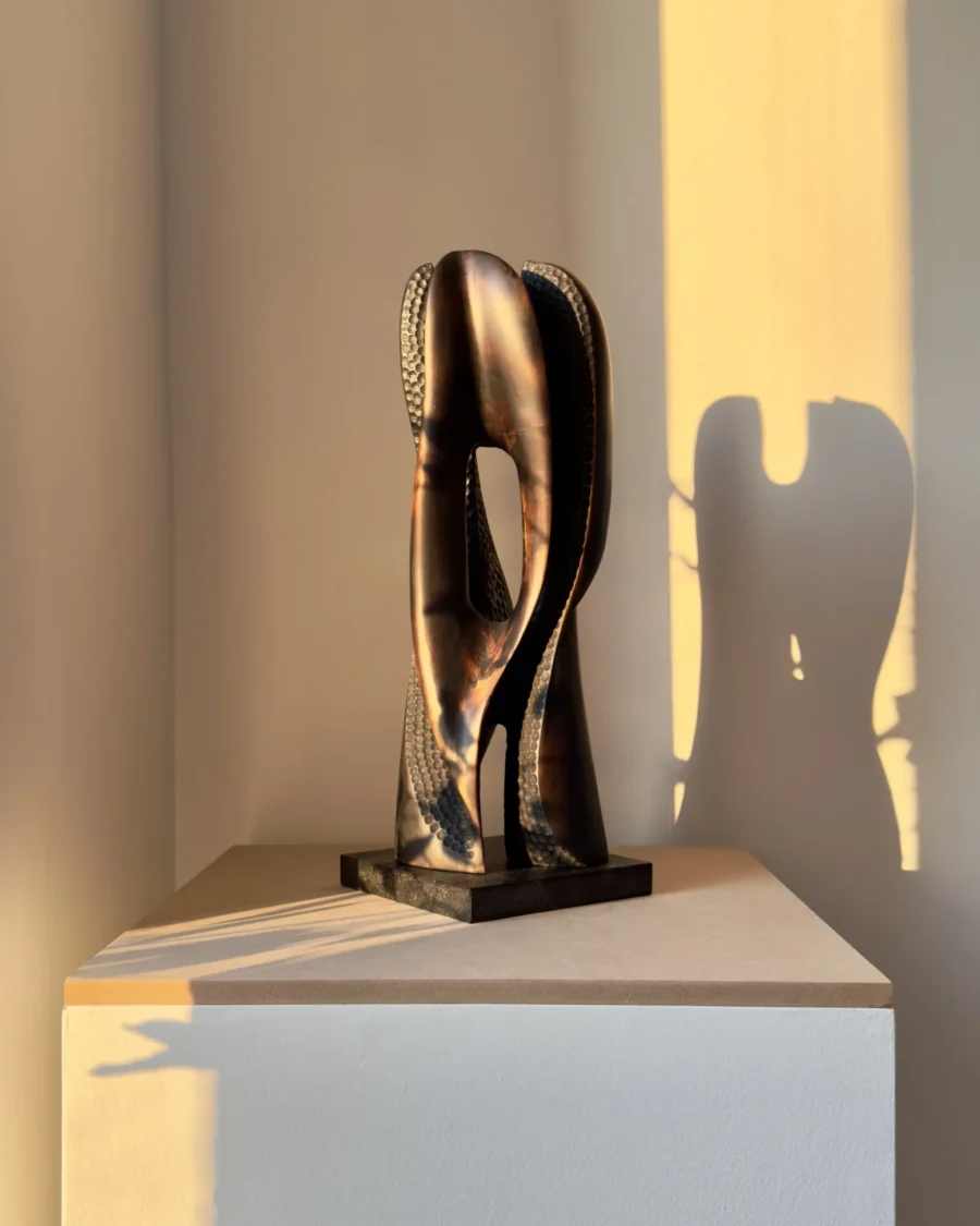 hand carved wood sculpture with strong shadow on wall
