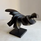 Dark Expansion sculpture viewed from an angle, showing layered organic forms and hand-carved textures in black pear wood