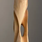 Side view of tall wooden sculpture with inner passage opening