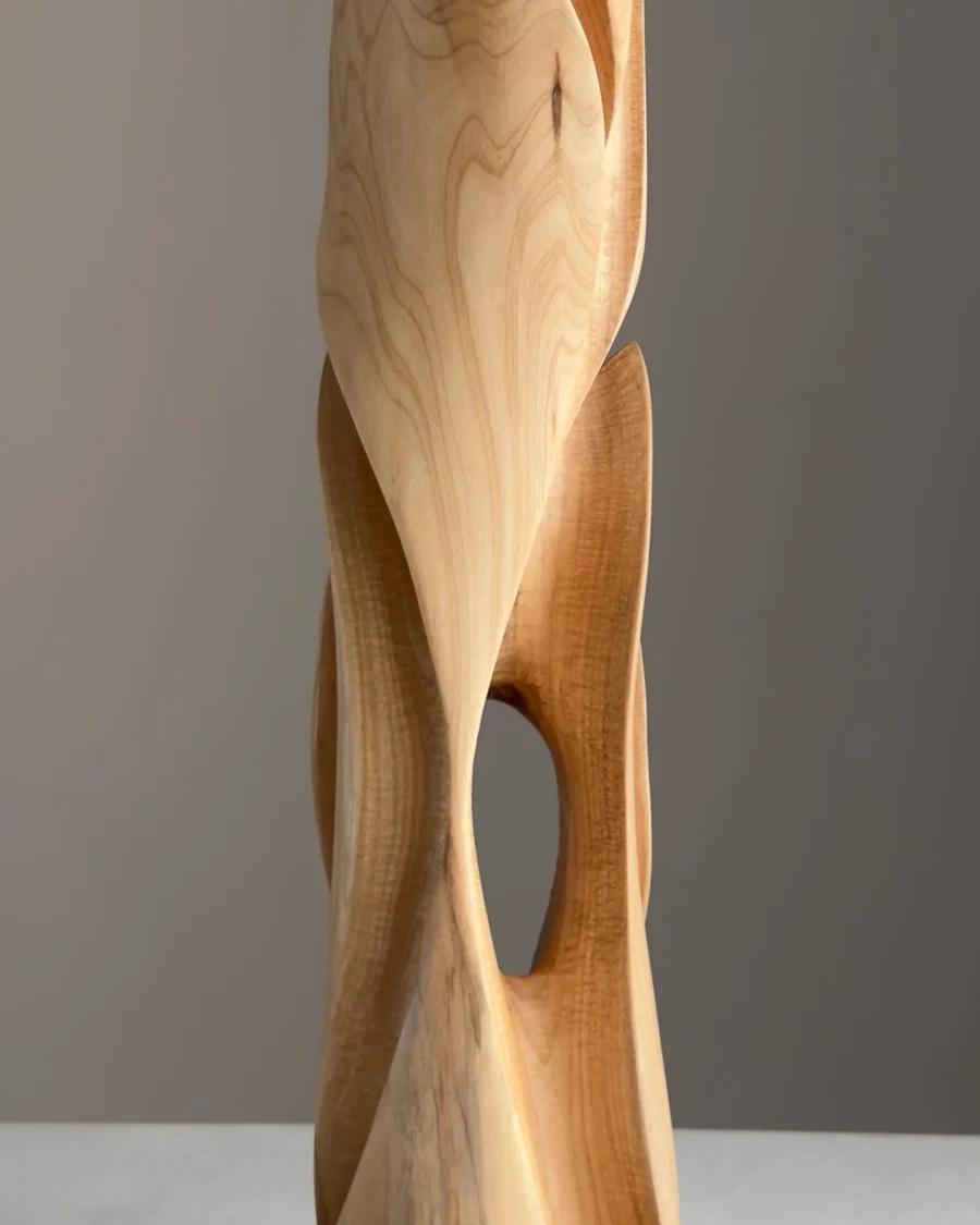 Side view of tall wooden sculpture with inner passage opening