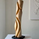 Side view of tall wooden sculpture with inner passage opening