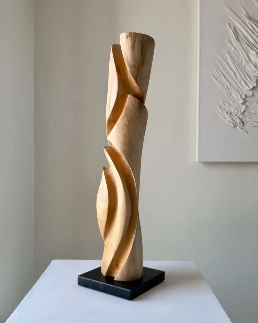 Side view of tall wooden sculpture with inner passage opening