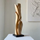 Hand-carved maple wood sculpture with flowing vertical form on granite base