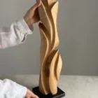 Wooden sculpture held in hands showing scale and proportions