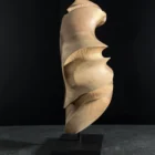 quiet-arc-abstract-wood-sculpture-side-view Modern wood sculpture with organic curves, walnut grain highlighted by directional light and deep shadows