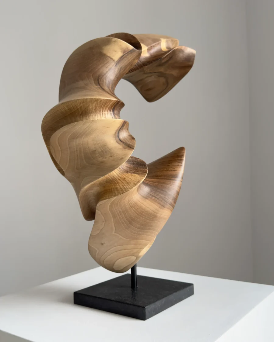 quiet-arc-walnut-wood-sculpture-side-view-ewebohome side view Hand carved walnut wood sculpture "Quiet Arc" on light background, abstract organic form with flowing curves and light shadow contrast