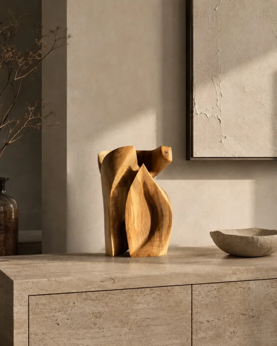 Hand-carved walnut wood sculpture Quiet Endurance displayed on a stone console in a contemporary Japandi interior with warm natural light.