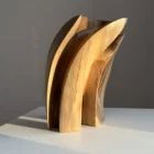 Quiet Endurance contemporary walnut sculpture displayed on a white pedestal