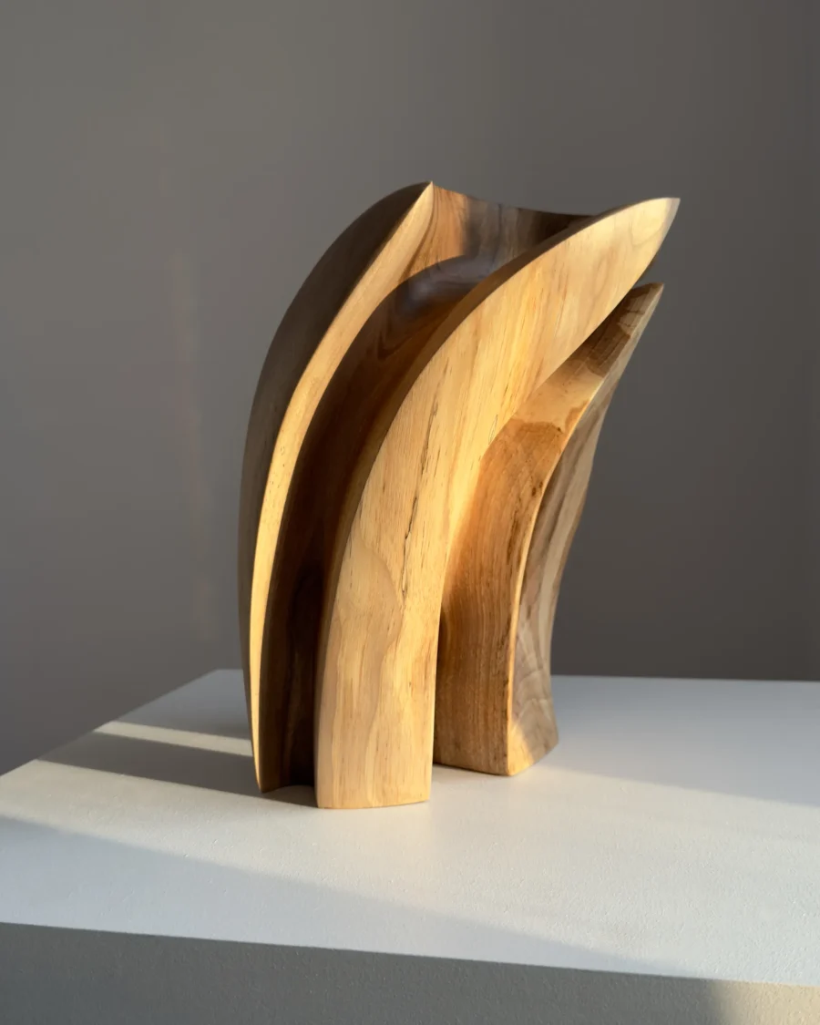 Quiet Endurance contemporary walnut sculpture displayed on a white pedestal