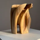 Quiet Endurance hand carved walnut wood sculpture viewed from the front in natural sunlight